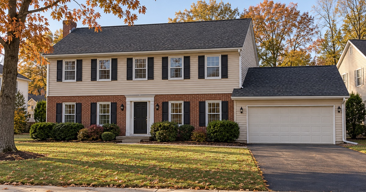 A finished new charcoal shingle roof on a 1970s brick-front colonial in Bensalem Township on a calm autumn afternoon.